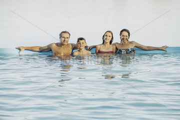 Family leaning against poolside