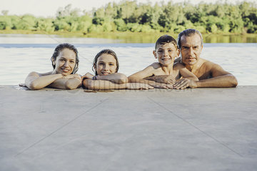 Family leaning on poolside