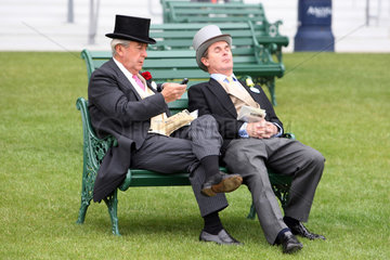 Ascot  Grossbritannien  elegant gekleidete Maenner sitzen auf einer Bank