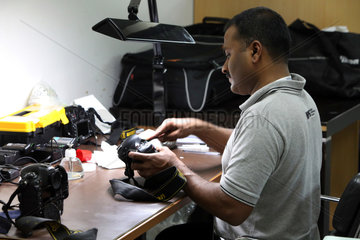 Dubai  Vereinigte Arabische Emirate  Mitarbeiter des Nikon Professional Service reinigt eine Spiegelreflexkamera