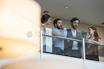 Business people using laptop on hotel balcony
