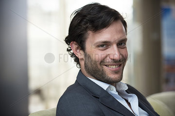 Close-up of businessman sitting in hotel lobby
