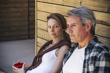 Couple sitting in front of log cabin