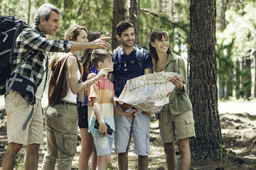 Family holding map in forest