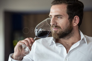 Close-up of mid adult man smelling red wine