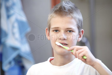 Hamburg  Deutschland  ein 13-jaehriger Junge mit Zahnspange putzt sich die Zaehne