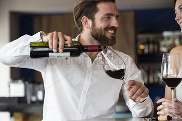 Mid adult man pouring red wine in glass