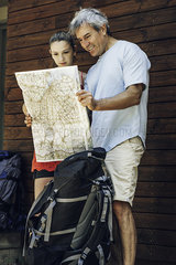 Father and daughter standing with map