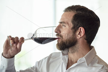 Mid adult man holding red wine glass
