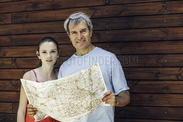 Father and daughter standing with map