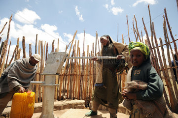 Mangudo  Aethiopien  eine Familie pumpt Wasser aus einem Brunnen