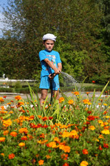 Domsarycy  Weissrussland  ein Junge besprengt ein Blumenbeet
