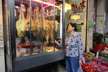 Hong Kong  China  Frau schaut sich geschlachtete Huehner auf einem Wochenmarkt an