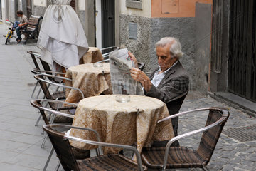 Acquapendente  Italien  Mann sitzt in einem Strassencafe und liest Zeitung