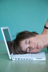 Berlin  Deutschland  Kopf einer Frau liegt erschoepft auf der Tastatur eines Laptops