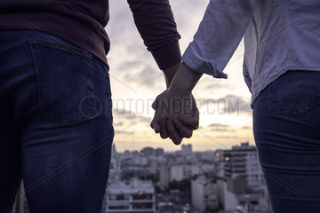 Couple standing on terrace and looking at cityscape