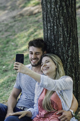 Young couple listening to music and taking selfie with a smartphone
