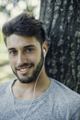 Close-up of smiling young man listening to music