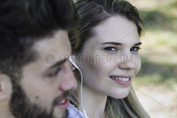 Young couple listening music on headphones