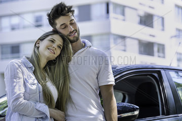 Couple standing near car