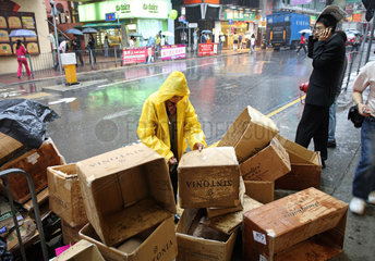 Hong Kong  China  Frau sammelt bei Regen alte Kartons ein