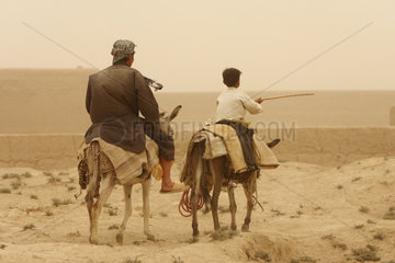 Kunduz  Afghanistan  Vater und Sohn reiten auf Eseln