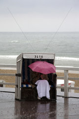 Westerland  Deutschland  Frau mit Regenschirm im Strandkorb