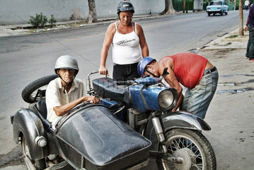 Havanna  Kuba  eine alte Frau sitzt im Beiwagen eines Motorrades und wartet