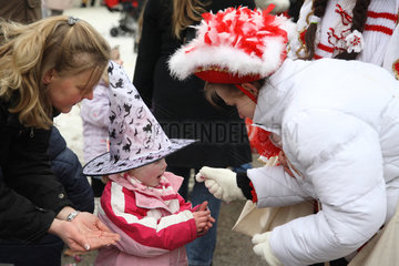Berlin  Deutschland  Funkenmariechen schenkt einem Kind Bonbons beim Karnevalsumzug