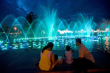Phnom Penh  Kambodscha  eine Famile beobachtet Wasserspiele an einem Brunnen