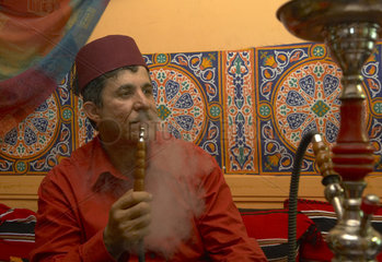 Berlin  arabischer Mann mit Fes raucht Wasserpfeife