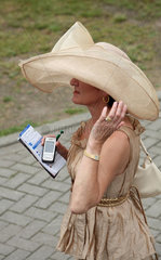 Hamburg  Deutschland  elegant gekleidete Frau mit Hut beim Pferderennen
