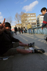 Istanbul  Tuerkei  ein Bettler mit verbrannten Beinen sitzt auf einer Bruecke