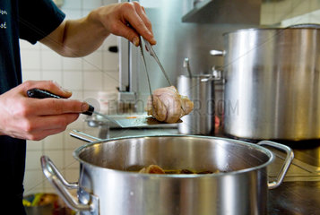 Berlin  Deutschland  Sternekoch Marco Mueller beim kochen von Eisbein