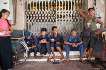 Yangon  Myanmar  Maenner beschaeftigen sich mit ihren Handys