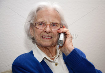 Berlin  Deutschland  eine aeltere Frau mit einem Mobiltelefon