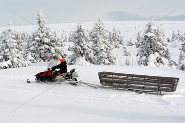 Saelen  Schweden  Mann faehrt auf einem Schneemobil mit Transportschlitten