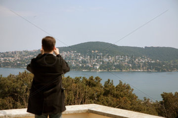 Heybeliada  Istanbul  Tuerkei  ein Mann blickt von Heybeliada auf die Nachbarinsel Bueyuekada