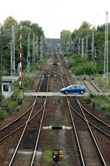 Rangsdorf  Deutschland  Auto faehrt ueber einen beschrankten Bahnuebergang