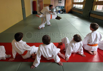 Berlin  Deutschland  Kinder in einem Judokurs. Judolehrer zeigt eine Wurftechnik
