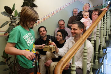Berlin  Deutschland  ein Junge gibt ein Treppenkonzert vor der Grossfamilie in ihrem Mehrgenerationenhaus