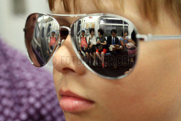 New York  USA  Fahrgaeste einer U-Bahn spiegeln sich in der Sonnenbrille eines Jungen