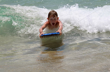 Santa Margherita di Pula  Italien  Junge im Meer sieht erschrocken Wellen auf sich zukommen