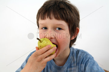 Berlin  Deutschland  Junge isst eine Birne