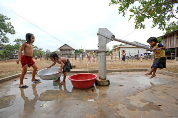 Phum Chikha  Kambodscha  Maedchen waschen sich am Dorfbrunnen
