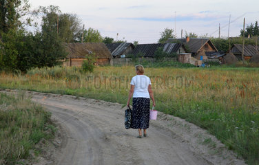 Kalnik  Weissrussland  eine Frau geht einen Landweg entlang