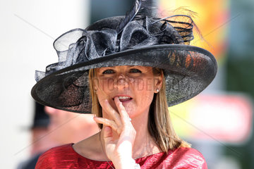 Ascot  Grossbritannien  Frau mit Hut schaut angespannt und kaut an den Fingernaegeln
