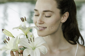 Young woman smelling lilies