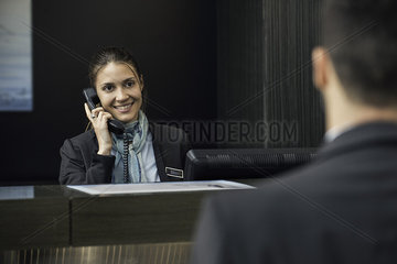 Hotel receptionist talking on phone