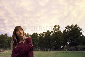 Young woman looking up in thought outdoors  portrait